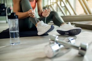 unrecognizable-athletic-woman-tying-sports-shoe-health-club unrecognizable-athletic-woman-tying-sports-shoe-health-club
